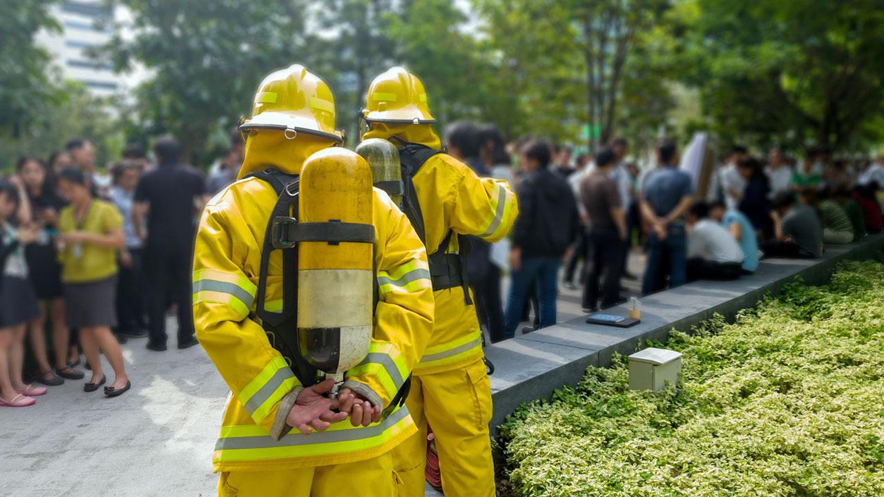 Firefighters and office workers practice emergency evacuation of high rise