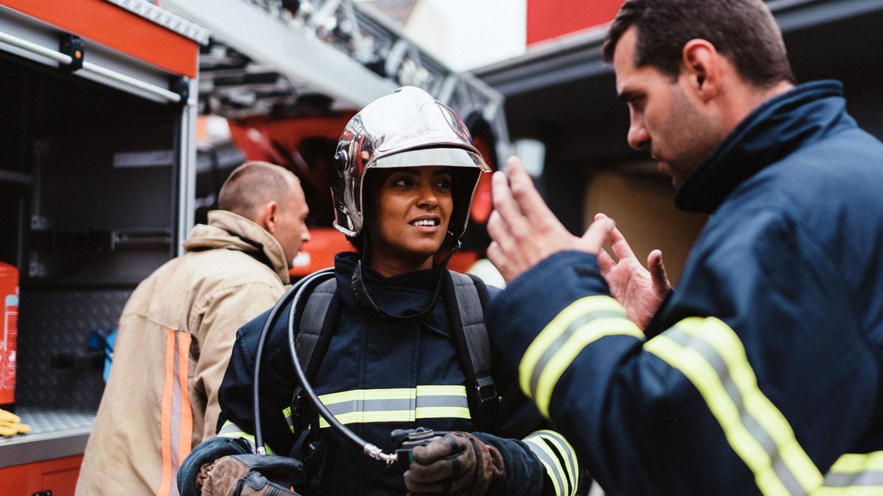 A trainer gives instruction to a firefighter during a disaster drill